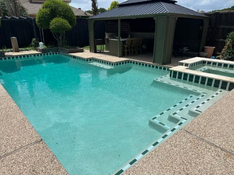 Pool technician vacuuming debris from backyard pool before a weekend gathering in Dallas