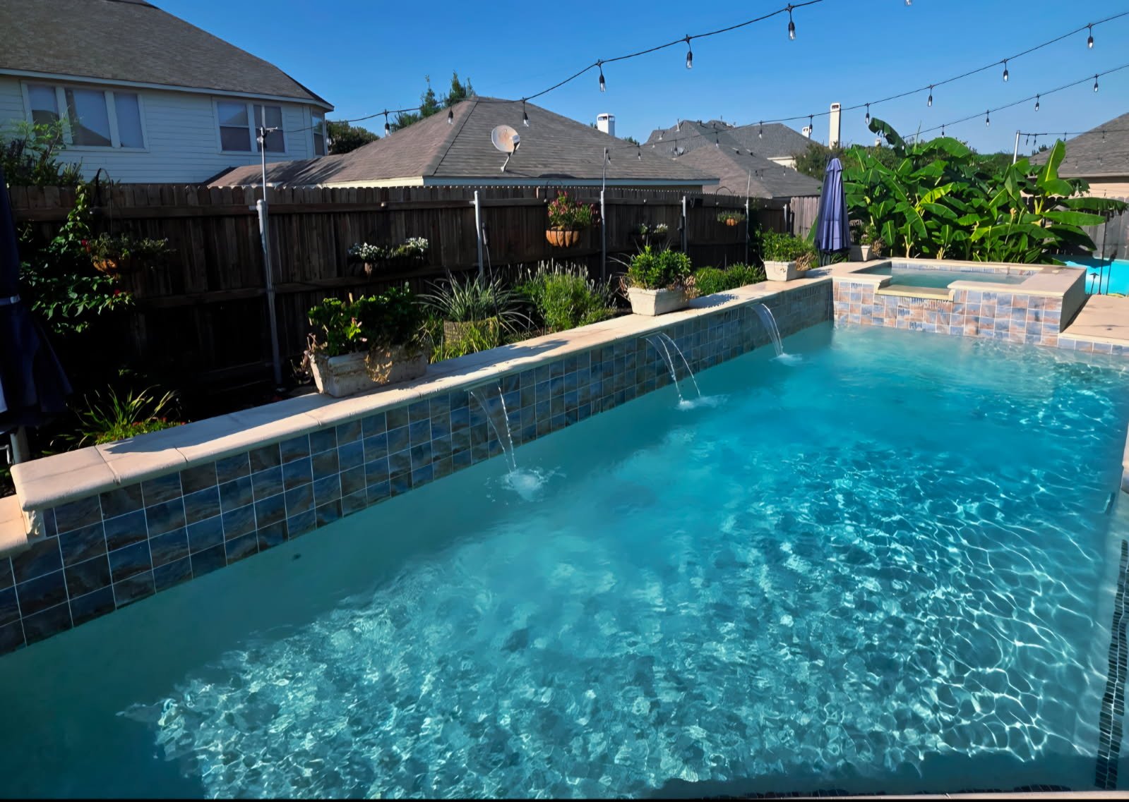 Pool technician vacuuming debris from backyard pool before a weekend gathering in Dallas