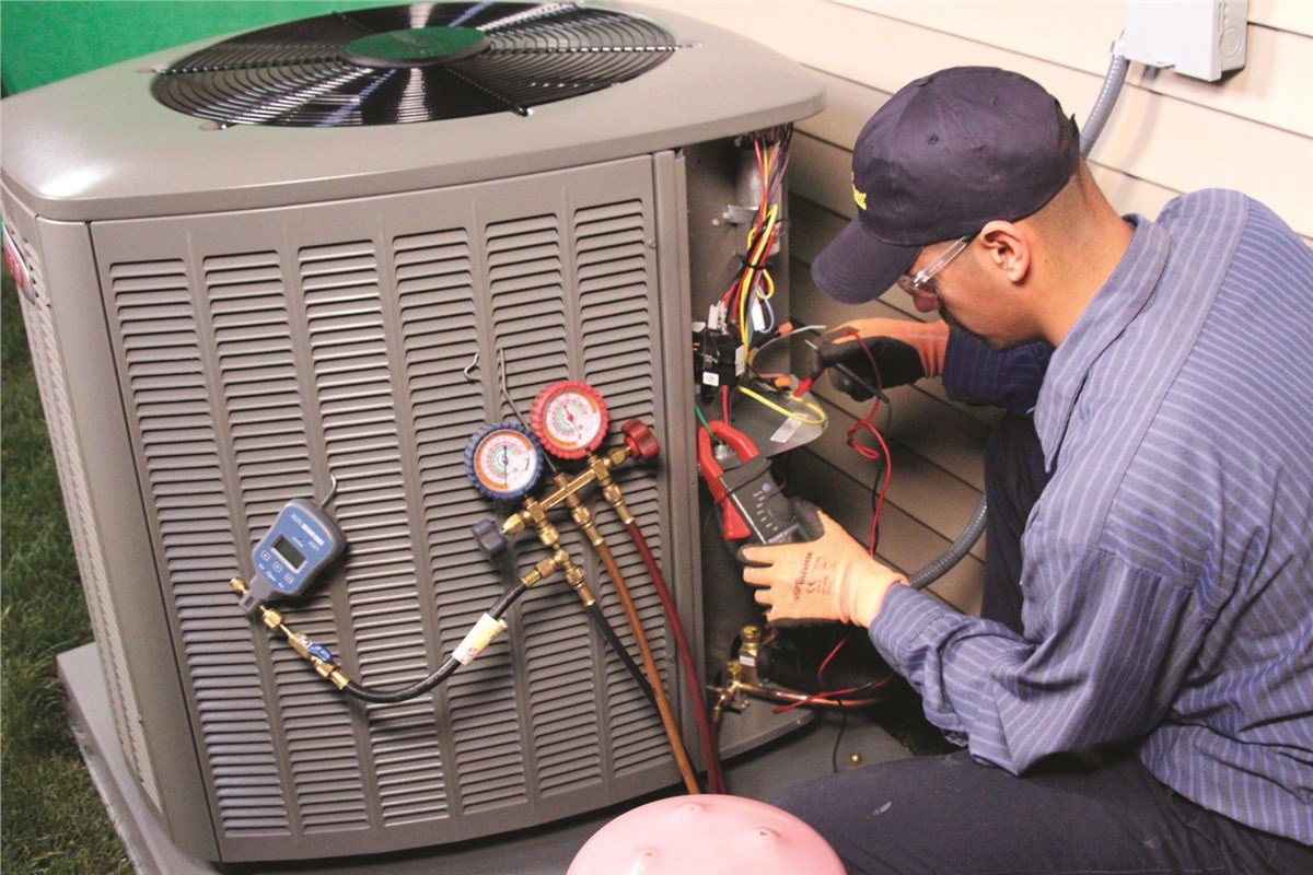 Experienced HVAC technician testing air conditioning components with diagnostic tools indoors